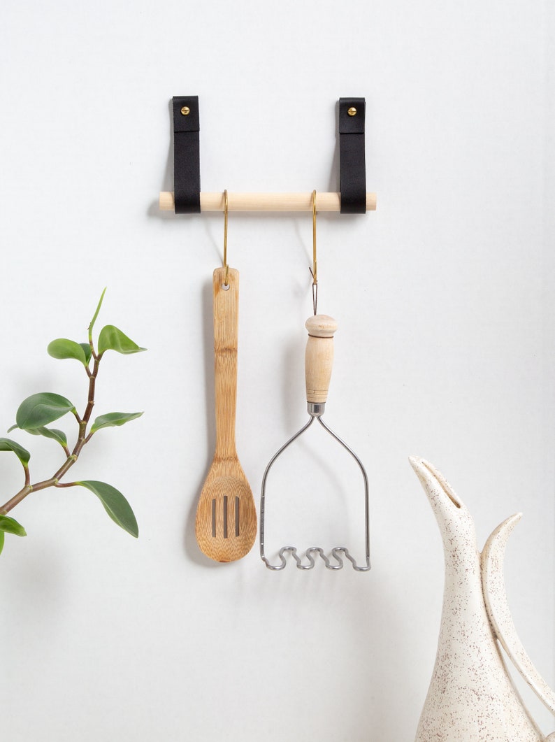 A Hanging Dowel Kit installed on the wall with kitchen accessories hanging.