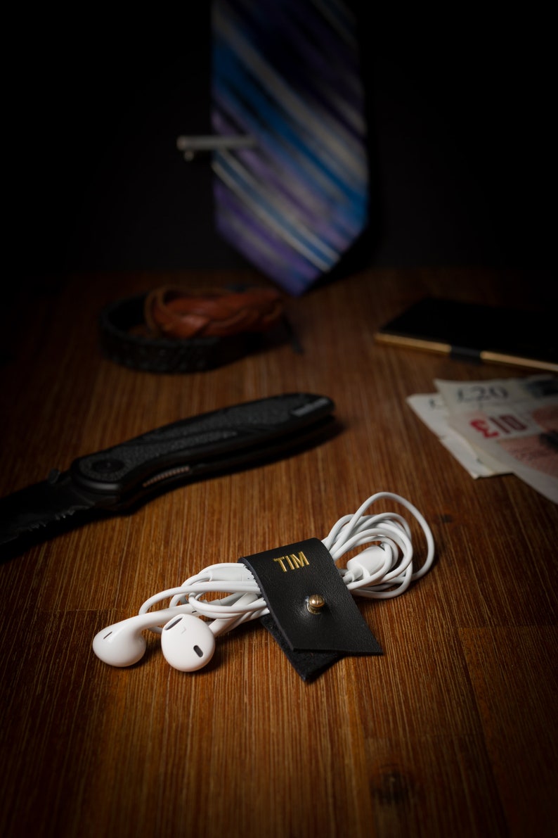 Small Leather Cord Holder displayed on an office desk wrapped around a cord.