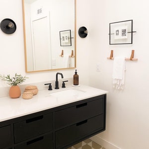 A wooden dowel used to hang a towel in a bathroom.