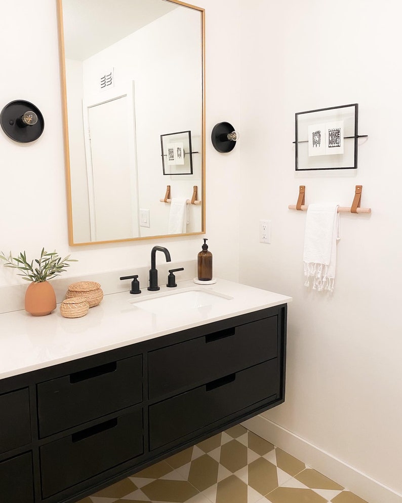 A wooden dowel used to hang a towel in a bathroom.