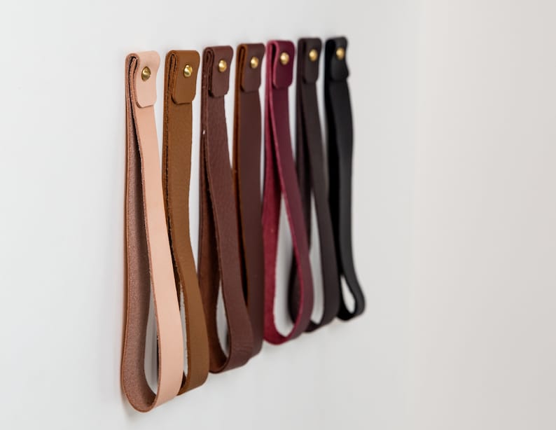 A row of installed wall straps lined up on a wall displaying all available colors.