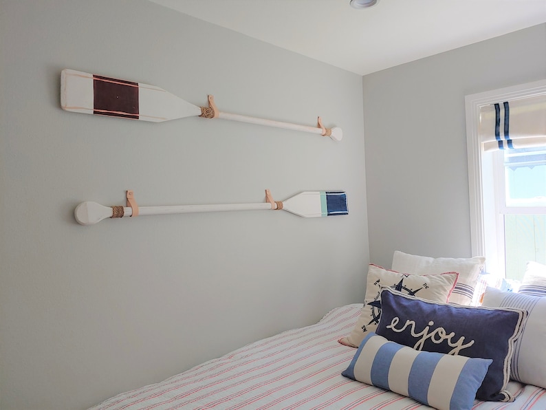 A marine themed bedroom showcases two oar paddles on the wall. 
Our Leather Wall Straps are used to hang oar paddles on the wall, the handle of the oar fits through the loop of the strap once installed.