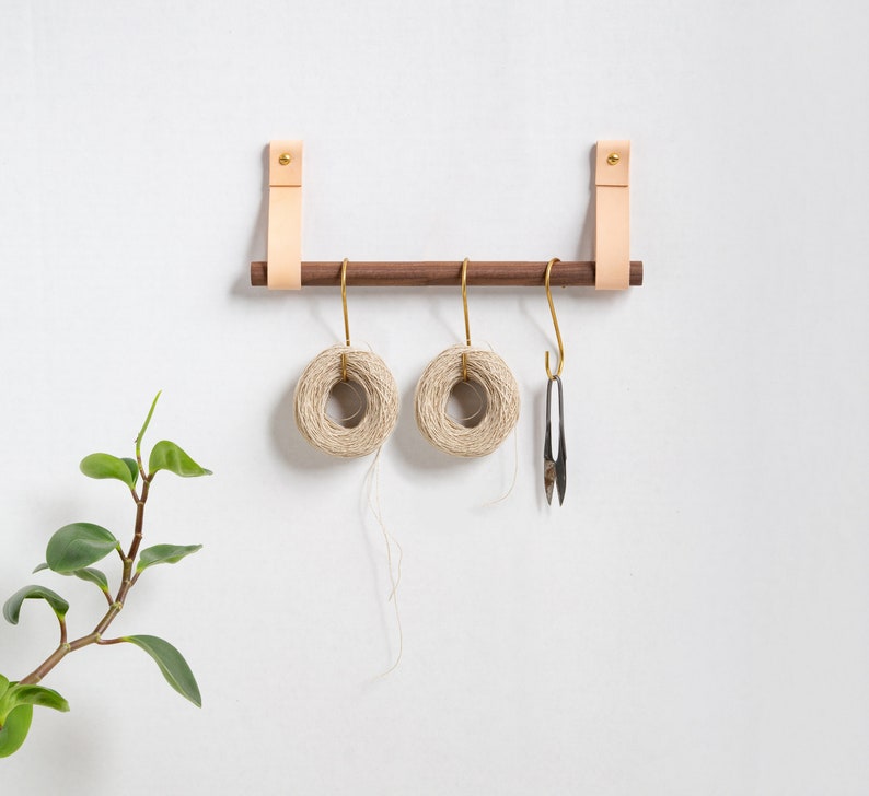 A Hanging Dowel Kit installed on the wall with kitchen accessories hanging.