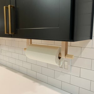 A Paper Towel Holder installed with Suspension Straps under a cabinet in a kitchen.