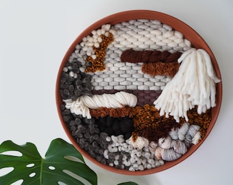 Large round terracotta clay framed weaving with textured rust and gray fibers