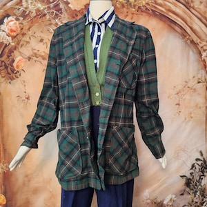 Könnte beinhalten: Ein langärmeliger Blazer mit einem dunkelgrünen, schwarzen und braunen Karomuster und zwei aufgesetzten Vordertaschen. Darunter befindet sich eine grüne Strickweste über einem weiß-dunkelblau vertikal gestreiften Hemd mit Kragen und dunkelblauer Hose.
