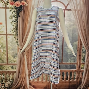 May include: A sleeveless, knee-length dress featuring a white base with horizontal stripes in navy blue, red, and yellow. The garment has a round neckline, a full-length front zipper closure, and a single patch pocket on the right side.
