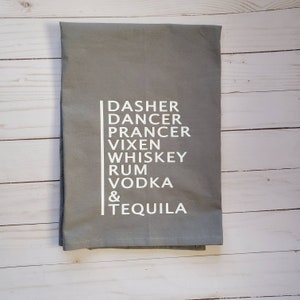 Puede incluir: Toalla de cocina gris con texto blanco que dice "Dasher Dancer Prancer Vixen Whiskey Rum Vodka & Tequila"