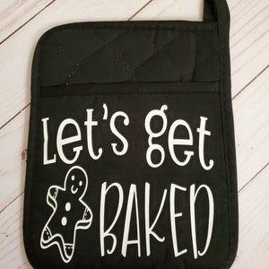 May include: Black oven mitt with white text that says "Let's get baked" and a gingerbread man graphic.