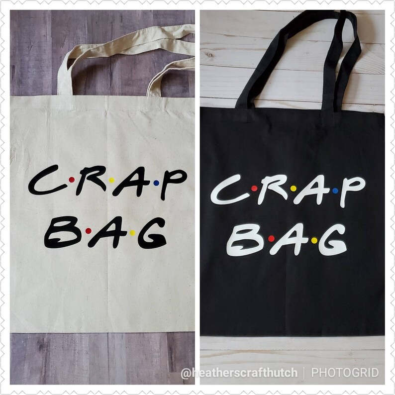 May include: Two tote bags with the text "C.R.A.P. B.A.G." in a white font with colorful dots. One bag is white and the other is black.