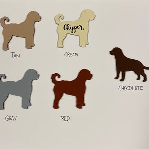 May include: Five dog silhouette cutouts in different colors: tan, cream, chocolate, gray, and red. The cream cutout has the word "Chipper" written on it.