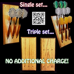 May include: Three wooden dart holders with different numbers of holes. The holder on the left has three holes and holds three darts with black and white checkered fletchings. The middle holder has three holes and is empty. The holder on the right has nine holes and holds nine darts with green, black and white checkered, and yellow fletchings. The text "Single set..." and "Triple set..." is visible above the holders. The text "NO ADDITIONAL CHARGE!" is visible below the holders.