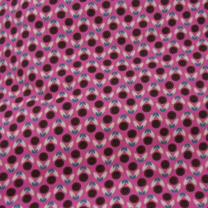 May include: Pink fabric with a repeating pattern of brown buttons and white and teal leaves.