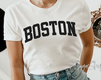 May include: White t-shirt with the word "BOSTON" printed in black block letters.