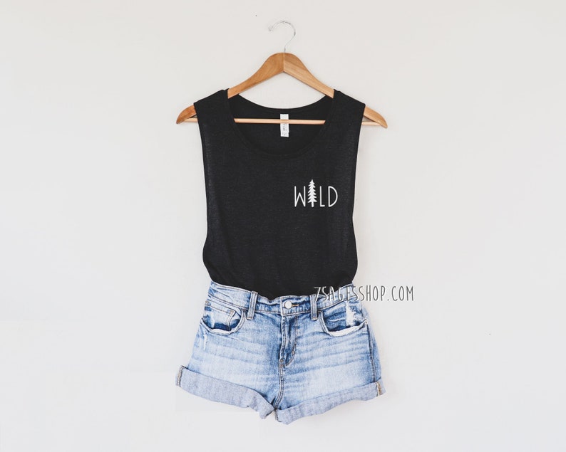 K&ouml;nnte beinhalten: Schwarzes &auml;rmelloses Tanktop mit einem wei&szlig;en Aufdruck eines Kiefernbaums und dem Wort "WILD".
