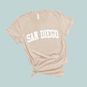 May include: A beige t-shirt with the text "SAN DIEGO" printed in white on the front.