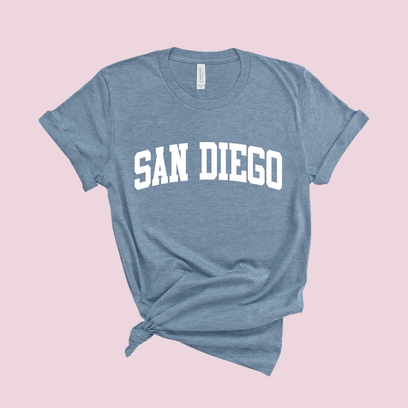 May include: A light blue t-shirt with the text "SAN DIEGO" in white, in a collegiate font.