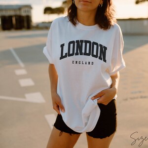 May include: White t-shirt with a black graphic that says "LONDON ENGLAND" in a collegiate font. Size shown is XL.