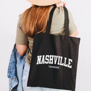 May include: A black tote bag with white text that reads "NASHVILLE TENNESSEE".
