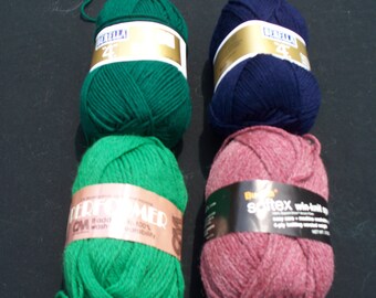 May include: Four balls of yarn in different colors: green, blue, pink, and green. The yarn balls have labels with the brand names "Berella" and "Softex".