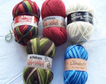 May include: Five skeins of yarn including a multicolored Patons Classic Wool, a solid red Patons Classic Wool, a white Bucilla knitting worsted, a brown and green striped Patons Classic Wool, and a blue variegated Lanaloft worsted weight yarn.