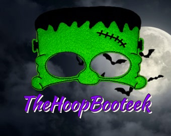 May include: Green felt Frankenstein monster eye mask with black felt hair and a stitched scar. The mask has eye holes for seeing. The mask is against a dark background with a moon and bats.