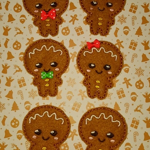 May include: Six felt gingerbread people ornaments with different colored bows. The gingerbread people are brown with white icing and yellow buttons.
