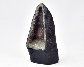 May include: A black amethyst geode with a large, open cavity revealing a cluster of sparkling, purple crystals.