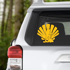 May include: A yellow silhouette of a hiker with a backpack and hiking poles, standing inside a stylized sunburst design. The design is on a white car window.