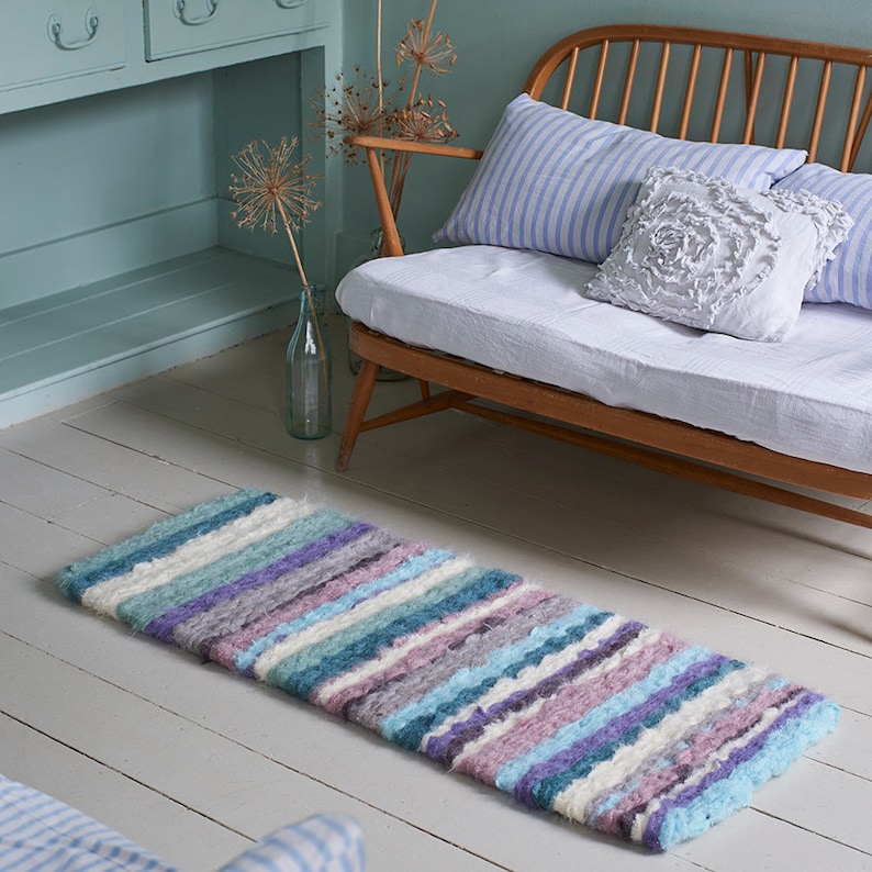 Handmade purple, blue and cream striped peg loom woven rag rug made using blanket selvedge strips. The quickest way to make a rag rug
