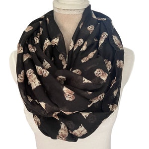 May include: A black infinity scarf with a repeating pattern of brown and white dogs.