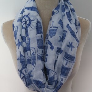 May include: A white infinity scarf with a blue nautical print featuring lighthouses, anchors, and stars.