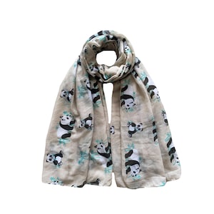 May include: A beige scarf featuring a repeating pattern of black and white panda bears and teal bamboo. The scarf is lightweight and made of a soft fabric, ideal for warmer weather. The scarf is approximately 180cm in length.