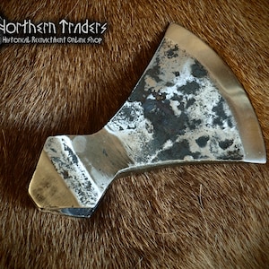 May include: A hand-forged axe head with a slightly curved blade and a rectangular handle. The axe head has a rough, hammered finish and is made of steel.