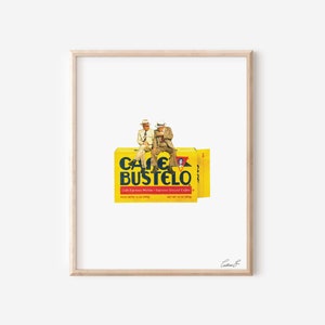Pode incluir: Dois homens com chap&eacute;us de cowboy e roupas de vaqueiro est&atilde;o sentados em cima de uma caixa amarela de caf&eacute; Cafe Bustelo. A caixa tem texto vermelho e branco que diz "Cafe Bustelo" e "Cafe Expresso Molido - Espresso Ground Coffee".