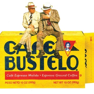 Pode incluir: Uma caixa amarela com o texto "Cafe Bustelo" em letras azuis. A caixa &eacute; etiquetada "Cafe Espresso Molido Espresso Ground Coffee" e tem um peso l&iacute;quido de 10 on&ccedil;as (283 gramas). Dois homens de terno est&atilde;o sentados em cima da caixa.