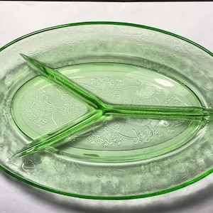May include: A vintage green glass divided serving dish with a floral pattern. The dish has three sections and is perfect for serving snacks or appetizers.