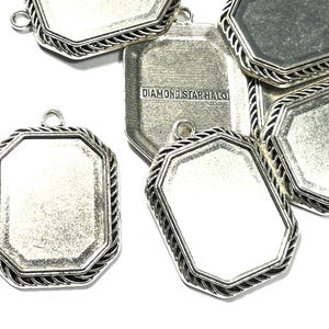 Puede incluir: Bandejas de colgantes plateadas con un borde de cuerda. Las bandejas son octogonales y tienen una superficie lisa y reflectante. El texto "DIAMOND STARHALO" es visible en una de las bandejas.