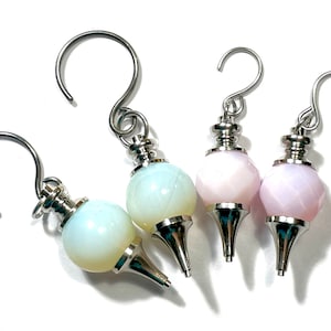 May include: Three silver and crystal pendulum charms with hooks. Two are light blue and one is light pink.