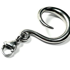 May include: A silver-colored, curved hook with a lobster clasp. The hook has a smooth, polished finish and a rounded, spiral shape. The clasp is attached to the hook with a small ring. The hook is designed to be used for hanging items.