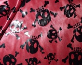 Black Skull And Cross Bone Foil on Red Shiny Light Weight Knit Halloween Costume Apparel by the yard fabric