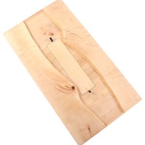 May include: A light wood table top with a natural edge and a rectangular cutout in the center.
