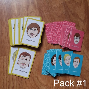 May include: A selection of card decks with illustrated portraits and names printed below. The cards are in various colours, including yellow, pink, and blue. The text "Pack #1" is visible at the bottom of the image.