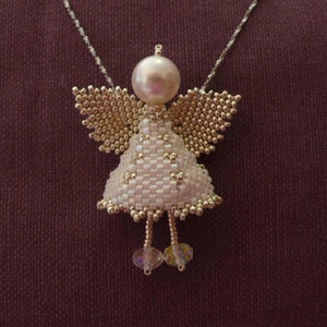 Può includere: Un ciondolo a forma di angelo in perle bianche con una testa di perla e dettagli in cristallo appeso a una catena d'argento. L'angelo indossa un abito bianco con un bordo dorato e ha ali di perle dorate.
