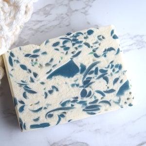 May include: A white bar of soap with a blue and green floral pattern.