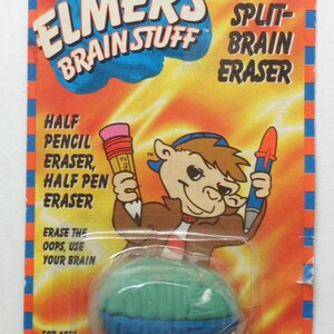 May include: Elmer's Brain Stuff Split-Brain Eraser package. The package features a cartoon camel holding a pencil eraser and a pen eraser. The eraser is blue, green, and white. Text includes "Half Pencil Eraser, Half Pen Eraser."