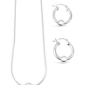 May include: A silver necklace and matching earrings with a round bead design. The necklace is a snake chain style.