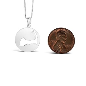 Puede incluir: Collar de plata con un colgante con forma del contorno de Martha's Vineyard. El colgante es aproximadamente del tama&ntilde;o de una moneda de un centavo de d&oacute;lar estadounidense.