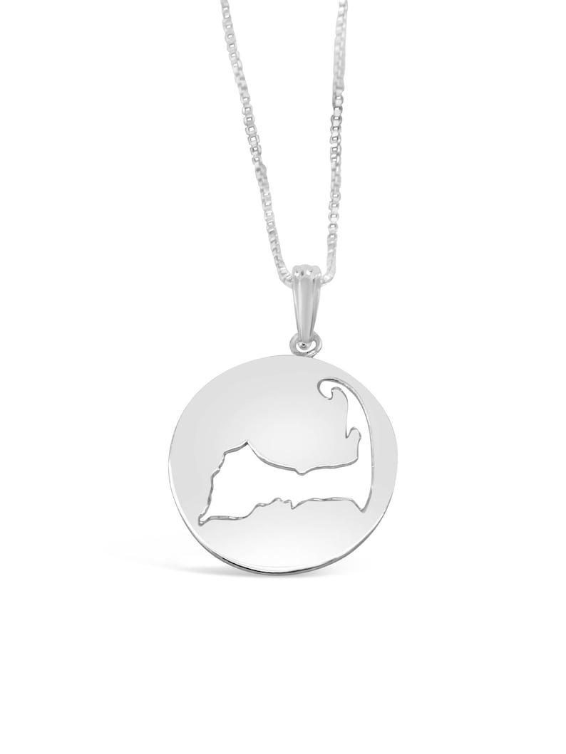 Puede incluir: Un collar de plata con un colgante circular que presenta un dise&ntilde;o recortado en forma de Cabo Cod.