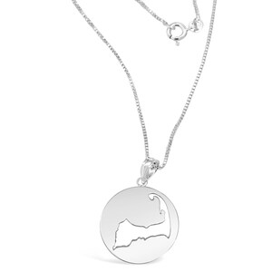 Puede incluir: Un collar de plata con un colgante circular que presenta un dise&ntilde;o recortado en forma de Cabo Cod.